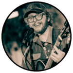 Liam Pendergrass performs, playing the guitar and singing.