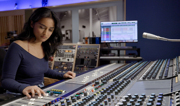 Student, Tanisha L., works on the recording studio controls.