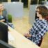 A student sits next to an interviewer at a table.